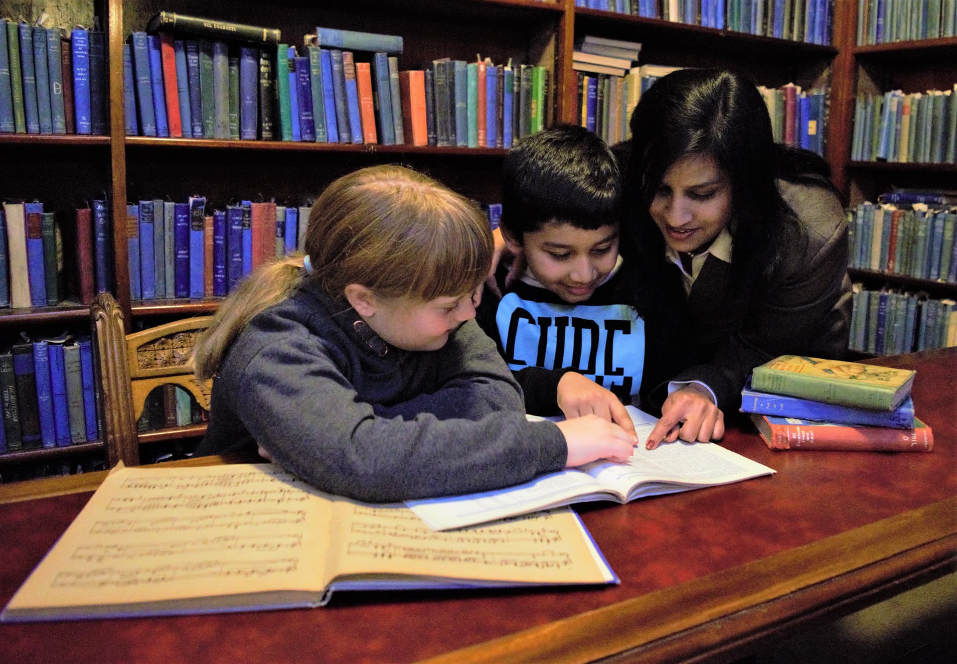 Tutor working with students in a library setting
